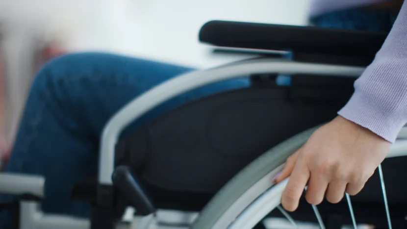 Primer plano de una persona sentada en una silla de ruedas preparándose para realizar sus ejercicios de rehabilitación